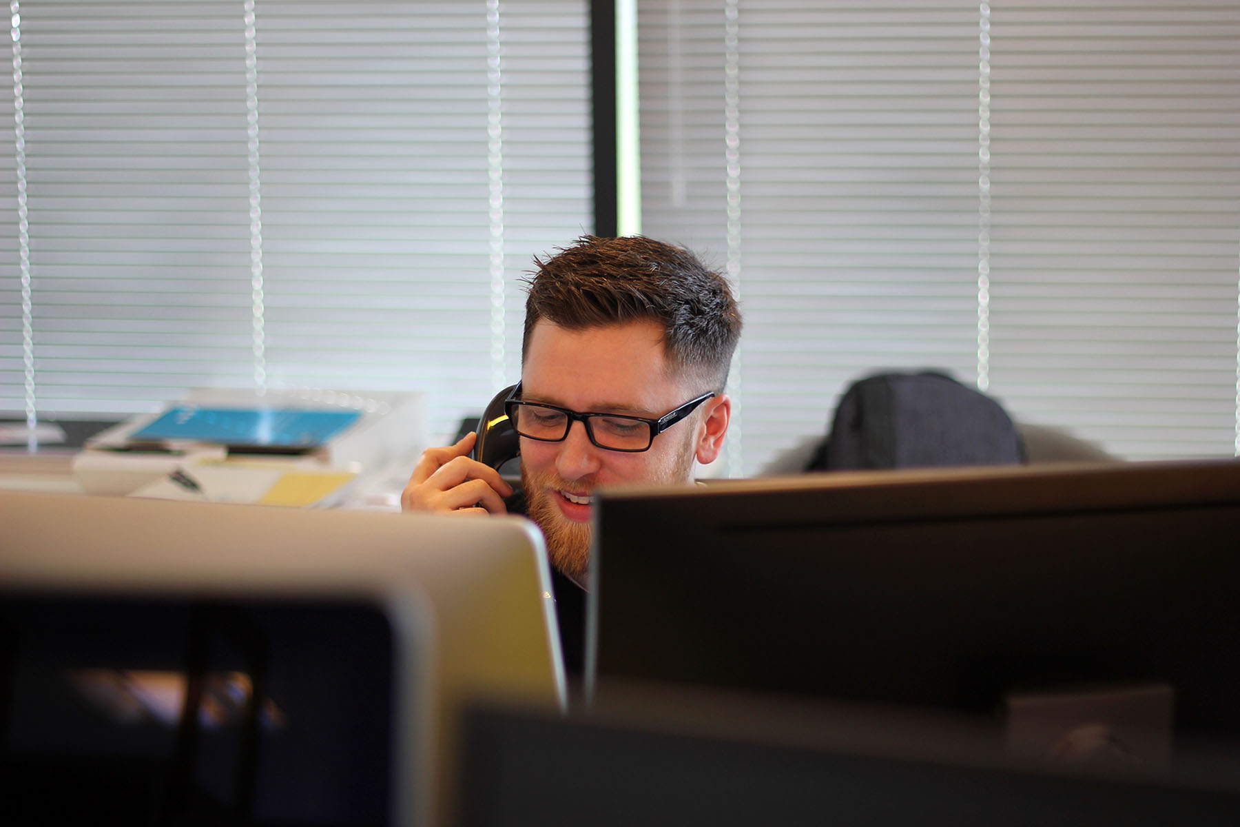 Man talking on phone at computer